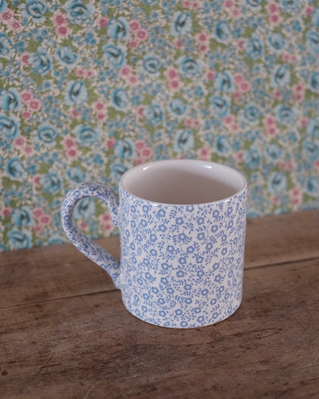 Mug céramique bleu pâle, décorée de motifs floraux sur la surface.